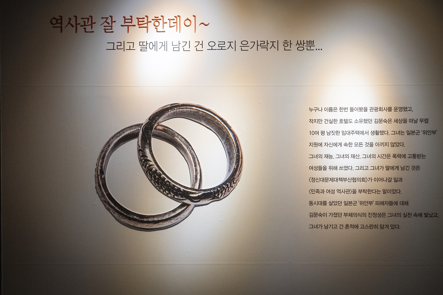 은가락지 한 쌍의 사진과 함께 &ldquo;역사관 잘 부탁한데이~ 그리고 딸에게 남긴 건 오로지 은가락지 한 쌍뿐&hellip;&rdquo;이라는 제목의 설명 글이 적힌 패널이다.