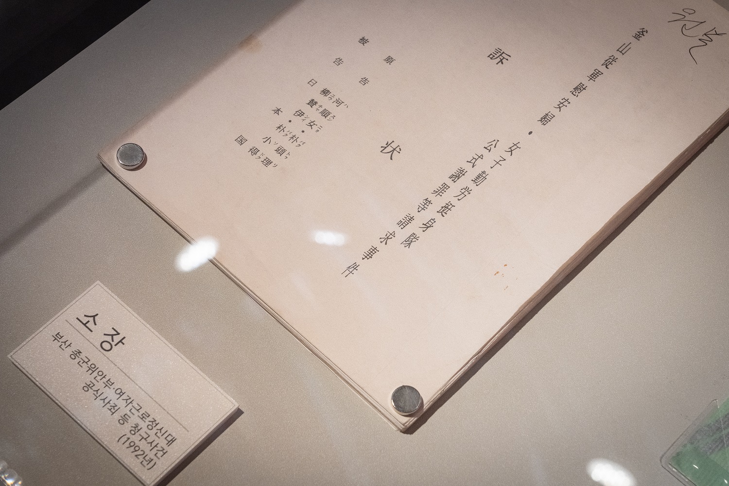 &lsquo;부산 종군위안부&middot;여자근로정신대 공식사죄 등 청구사건&rsquo; 소장(1992년)의 일본어 표지가 진열되어 있다.