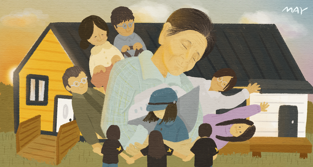 노란 집과 흰 집 앞에 눈을 감고 미소 짓는 박필근 할머니가 크게 그려져 있고, 그 주위로 여러 사람이 할머니에게 다가와 안기거나 손을 뻗고 있다. 앞쪽에는 노란 나비 배지를 단 사람들이 손을 맞잡고 둘러서 있으며, 뒤로 해가 떠오르고 있다.