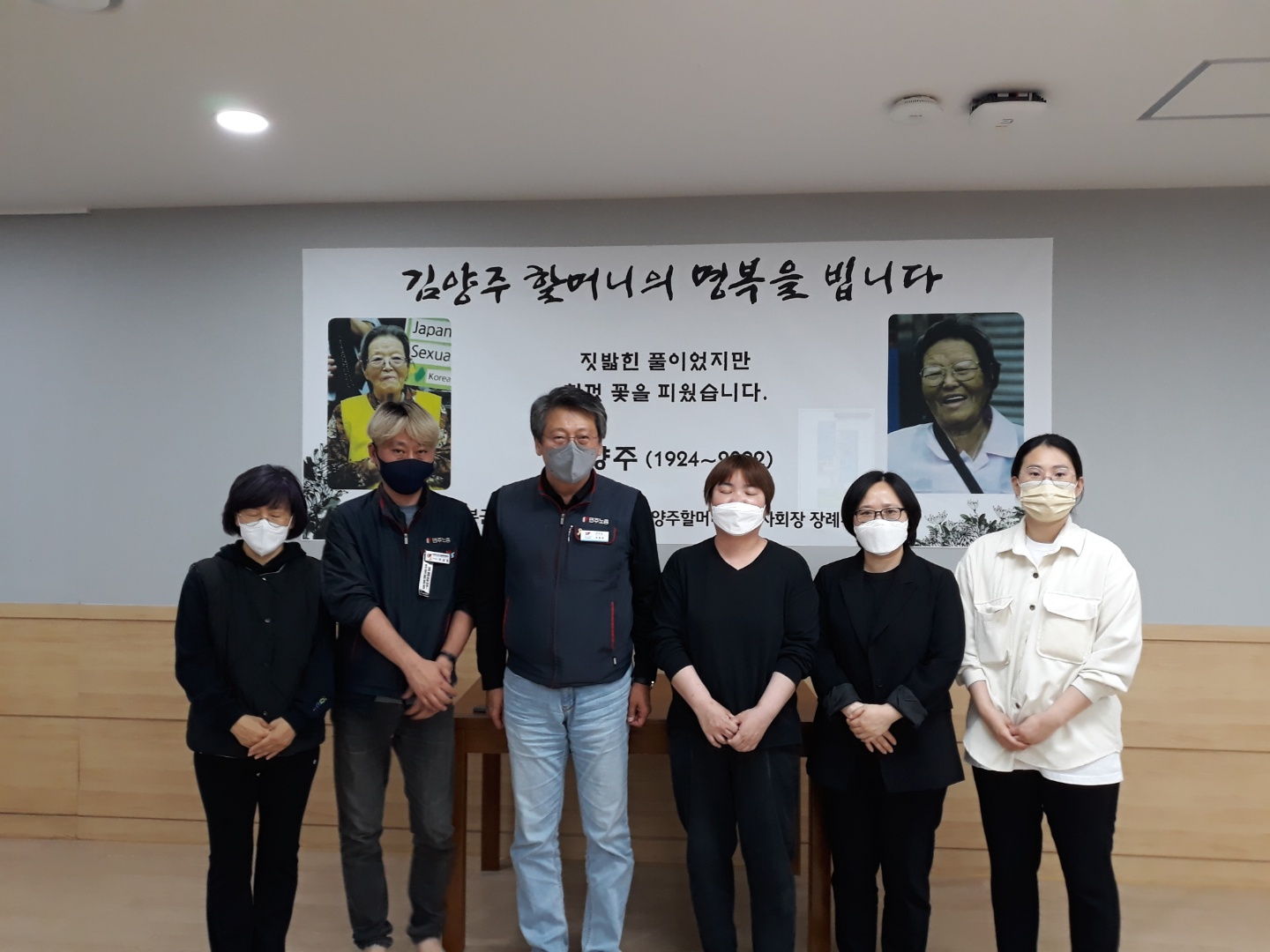 같은 현수막 앞에서 조문객 6명이 나란히 서서 찍은 사진이다. 현수막에는 김양주 할머니의 사진 두 장이 실려 있다.